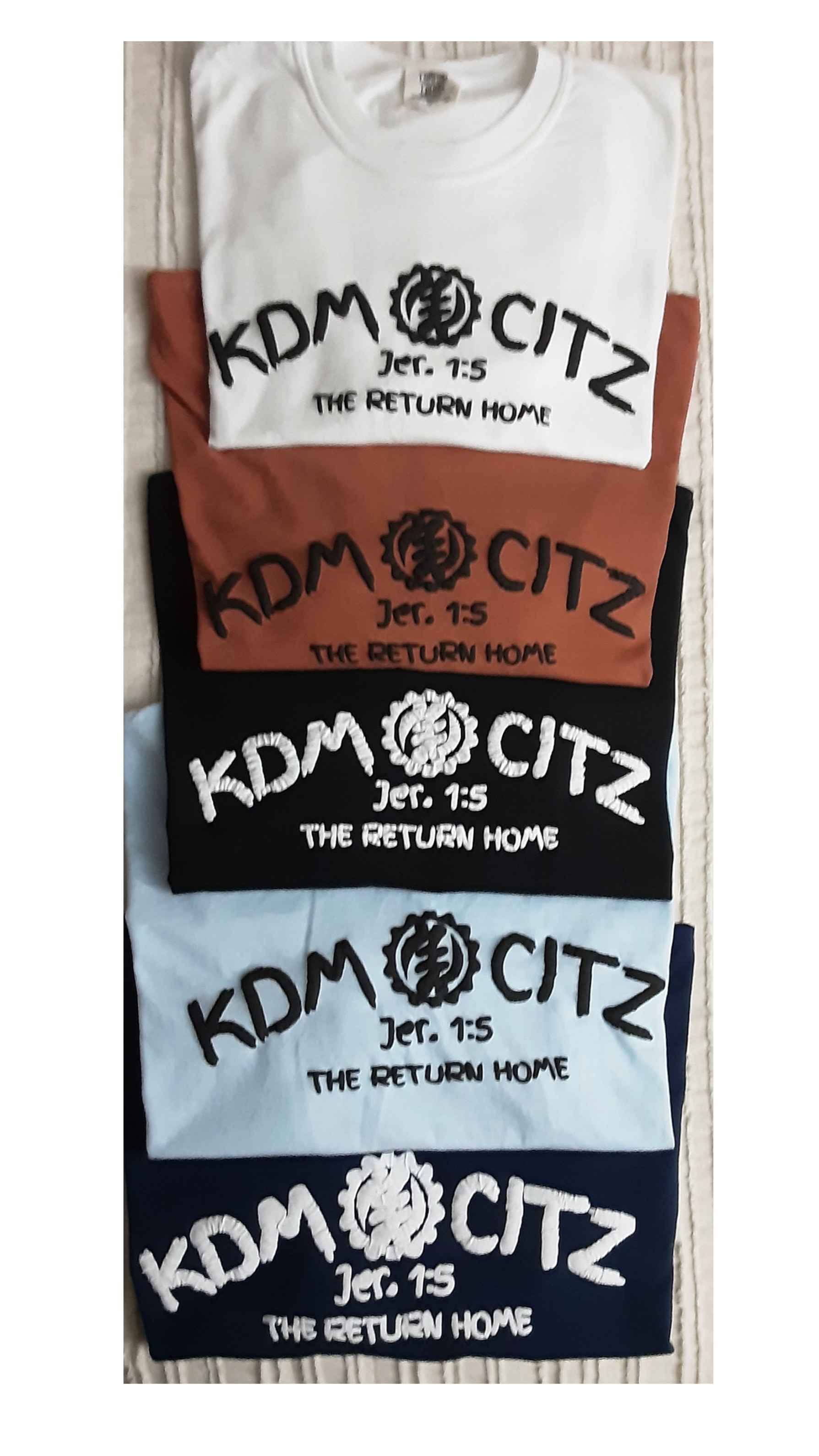 Four t-shirts with 'KDM CITZ' branding on a white background